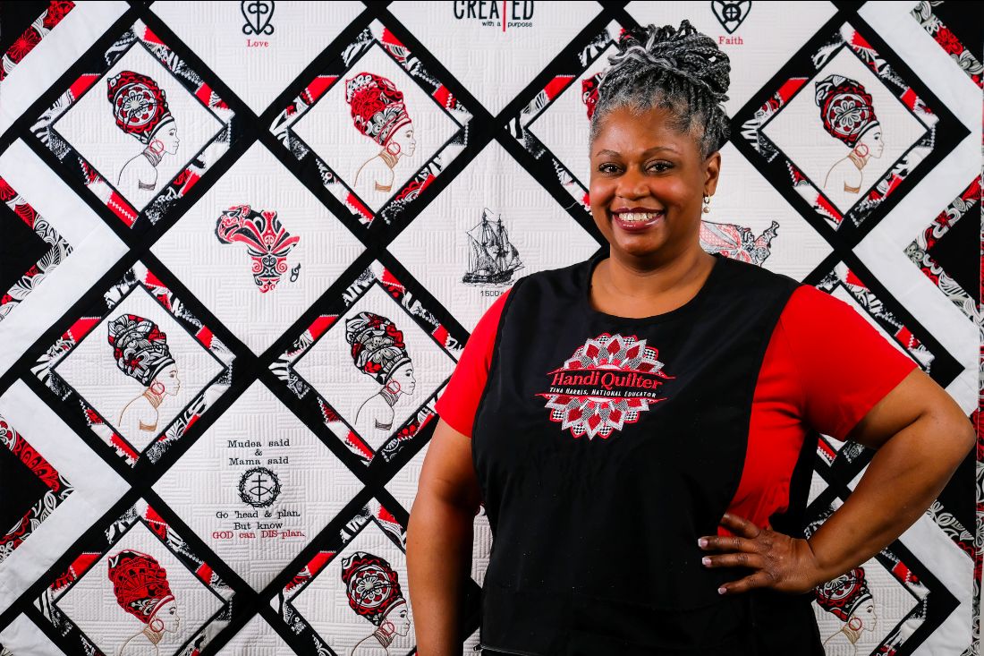 Tina Harris standing in front of her favorite quilt